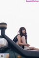 A woman sitting on top of a green car.