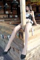 A woman sitting on top of a wooden bar.