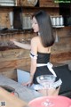 A woman in a black and white dress standing at a bar.