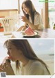 A woman sitting at a table eating a slice of watermelon.