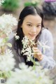 A young woman holding a bunch of white flowers.