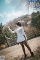 A woman in a white dress holding a sword.