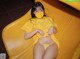 A woman wearing a yellow shirt and a face mask on a yellow slide.