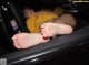 A woman laying in the back seat of a car with her feet up.