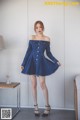 a woman in a denim dress posing for a picture