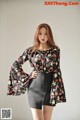 a woman in a black skirt and a floral blouse