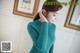 a woman wearing a green sweater and black pants