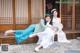 A couple of women sitting on top of a wooden bench.