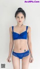 A woman in a blue bra and panties posing for a picture.