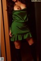 A woman in a green dress posing for a picture.