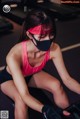 A woman wearing a face mask sitting on a stationary bike.