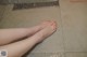 A woman's feet in a shower with water droplets on the floor.