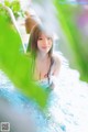 A woman in a white dress is sitting in a pool.