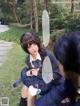 A man and a woman sitting on a bench in a park.