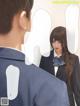 A man and a woman in school uniforms looking at each other.