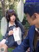 A man and a woman sitting on a bench in a park.