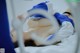 A woman laying on top of a bed in a blue and white outfit.