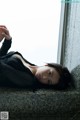 A woman laying on a ledge next to a window.