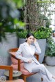 A woman in a gray suit sitting on a chair.