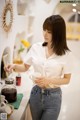 A woman standing at a counter holding a cup of coffee.