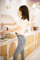 A woman standing in a kitchen next to a stove.