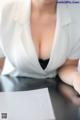 A woman in a white shirt is sitting at a table.