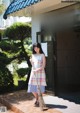 A woman holding a broom standing in front of a building.