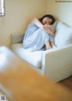 A woman is sleeping on a white couch.