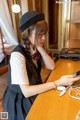 A woman sitting at a table looking at her phone.