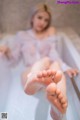 A woman sitting in a bathtub with her feet up.