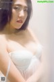 A woman in a white lingerie posing for the camera.